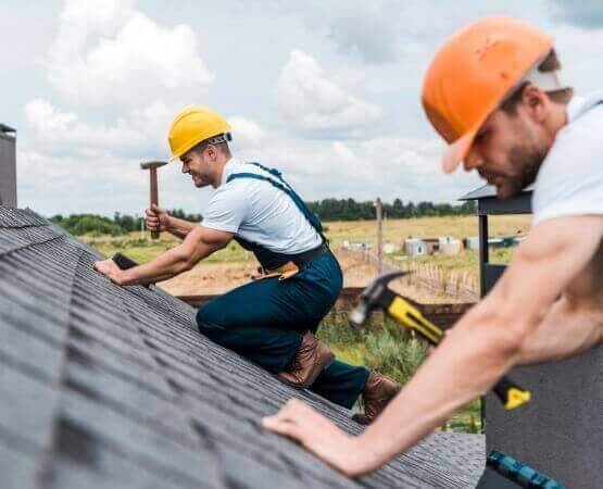 selective focus of handsome handyman repairing roof