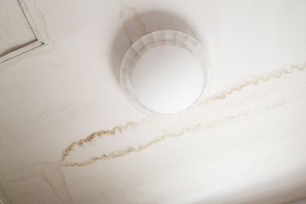 2 feet long water stains on a ceiling cause by a leaky roof