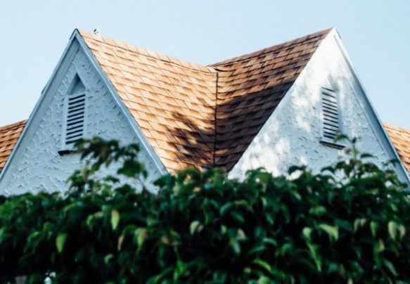 view on a white stucco'd house and slopped shingled roof